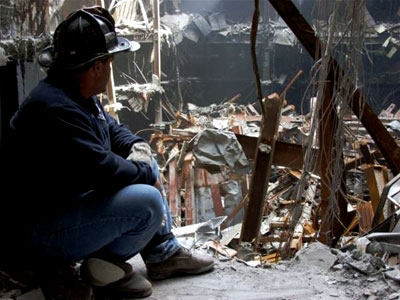 A hero firefighter pauses to look at the destruction