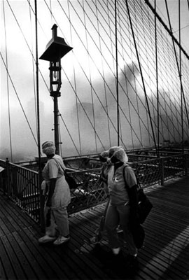 Hospital workers look back at the dust cloud at Gound Zero in lower Manhattan